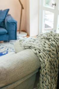 cozy blanket | therapy for women lynn, ma | women's therapist lynn, ma | women's issues therapy lynn, ma | lynn, ma | salem, MA | Winthrop, MA A cozy blanket sitting on a beige couch in a therapy room. Representing how women's counseling in Lynn, MA can support you with stress, burnout, parenting, & more. Get started with a therapist today.